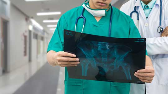 Surgeon-Examining-Pelvic-Reconstruction-Candidate-X-Ray